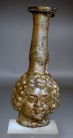 Roman light yellow glass Janus head tall flask.